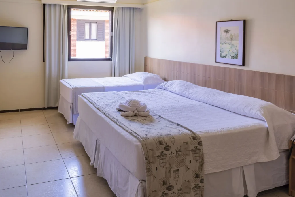 Apartamento Triplo Standard no Hotel Colonial Iguaçu, ideal para três pessoas, com camas confortáveis, ar-condicionado e ambiente acolhedor, perto das Cataratas do Iguaçu.