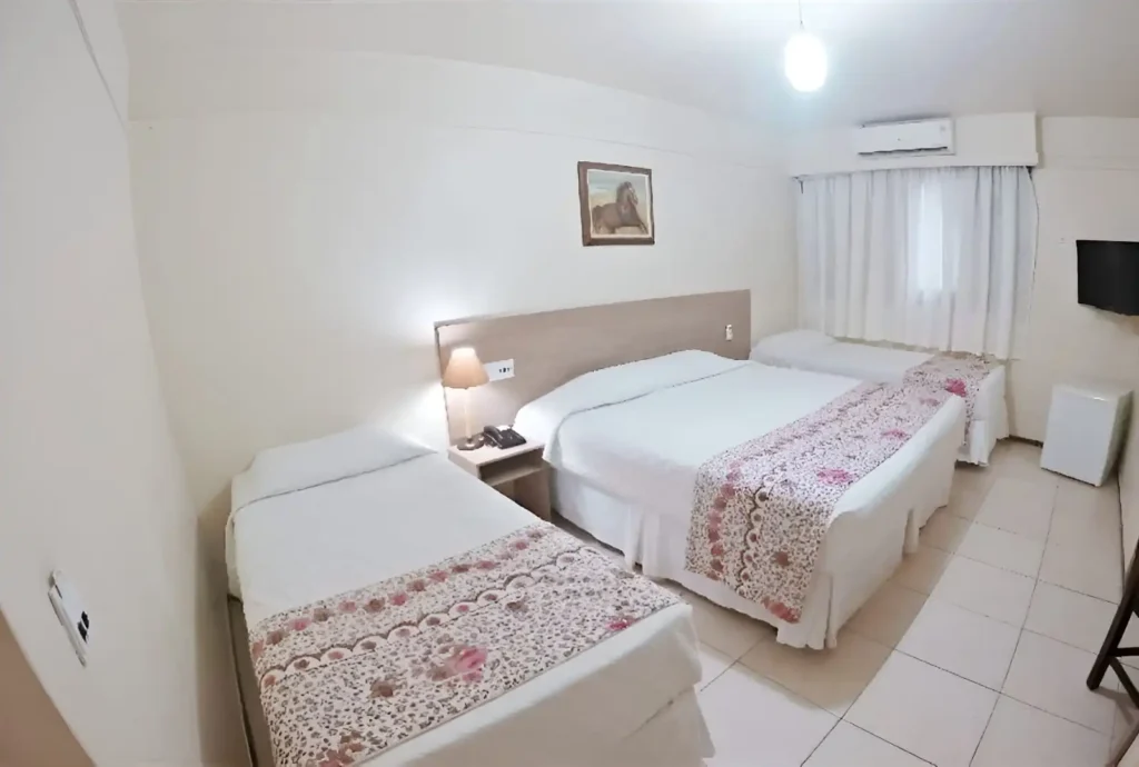 Apartamento Quádruplo Standard com duas camas de casal em ambiente funcional e iluminado no Hotel Colonial Iguaçu, ideal para famílias em viagem.