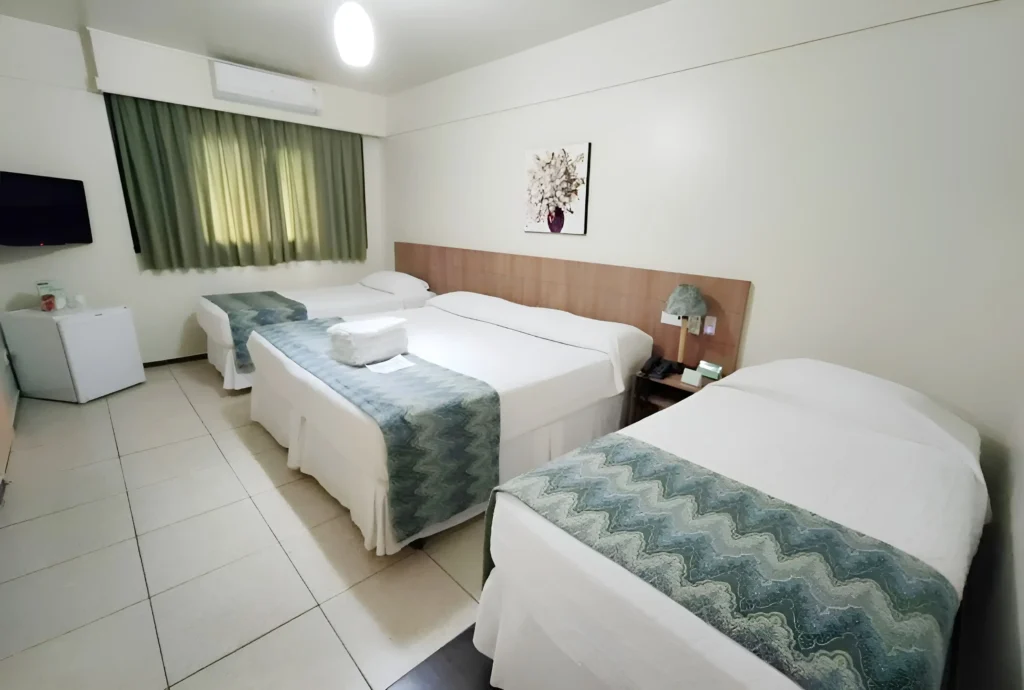 Apartamento Quádruplo Superior com duas camas de casal, localizado nos andares superiores do Hotel Colonial Iguaçu, ideal para famílias que buscam tranquilidade.
