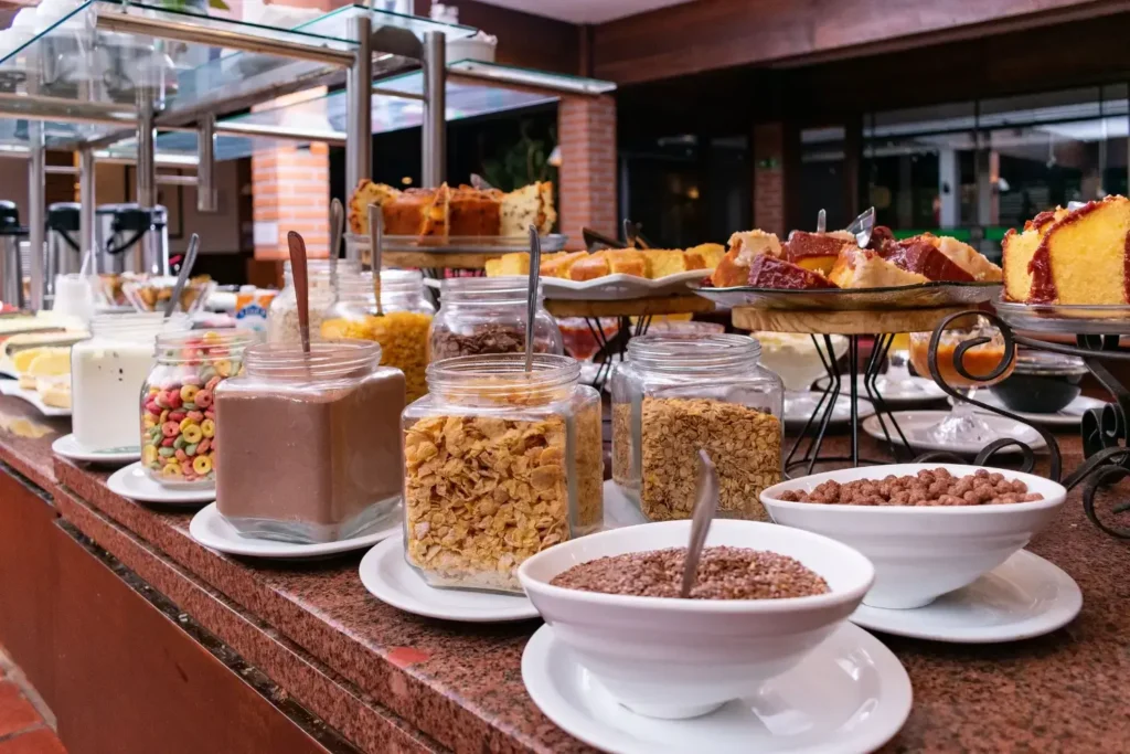 Mesa de café da manhã completa com cereais, iogurtes, frutas e pães no Hotel Colonial Iguaçu