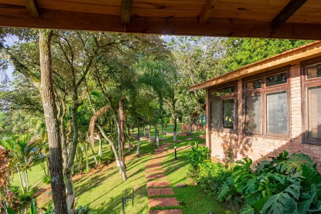 Área verde com jardim, árvores e trilha natural em hotel cercado pela natureza em Foz do Iguaçu.