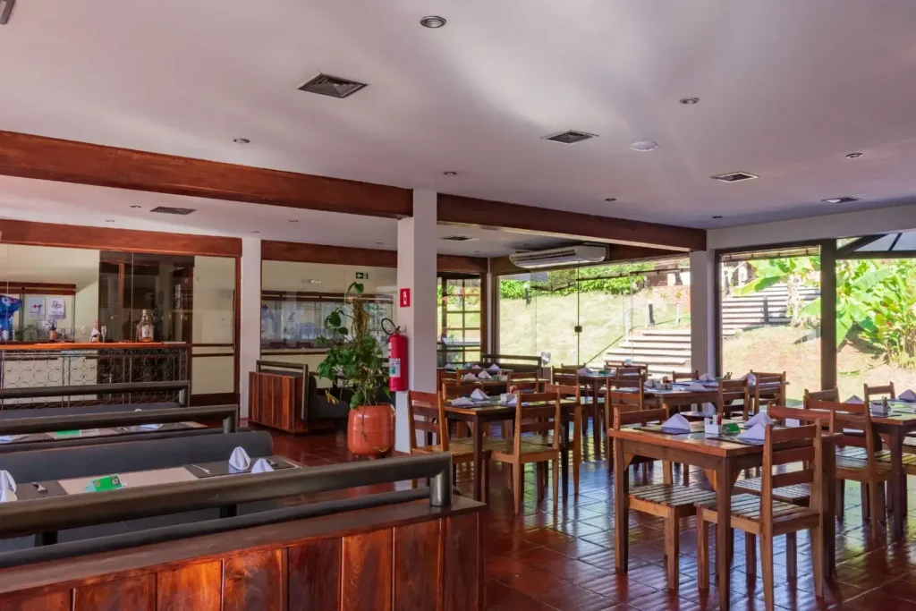 Restaurante do Hotel Colonial Iguaçu com ambiente rústico, iluminado e mesas bem organizadas