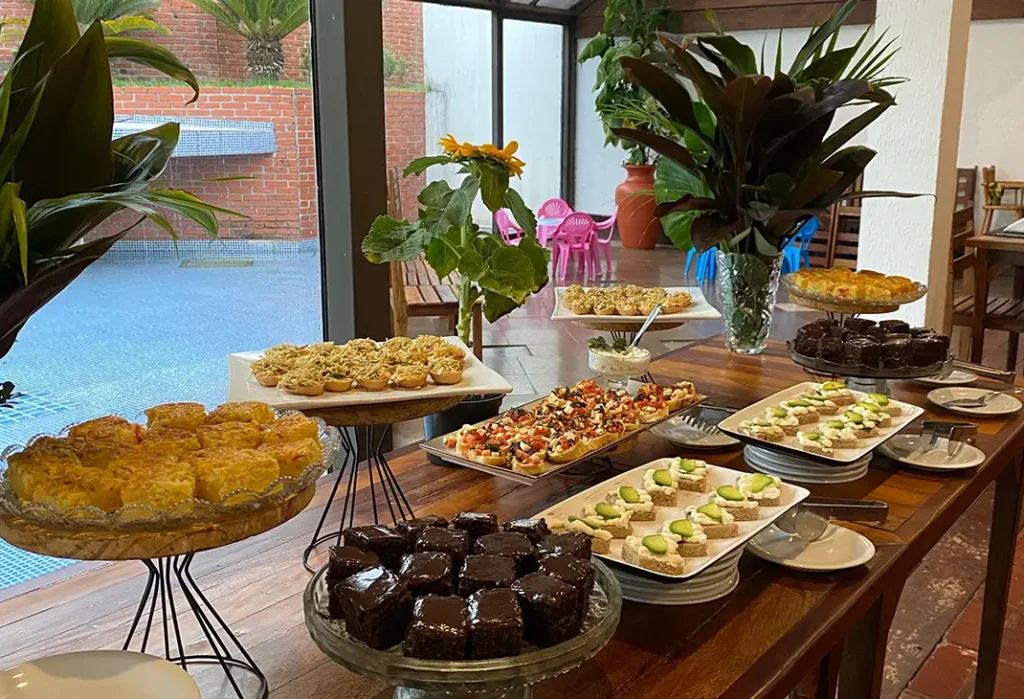 Buffet de café da manhã com pães, frutas e vista para a piscina no Hotel Colonial Iguaçu