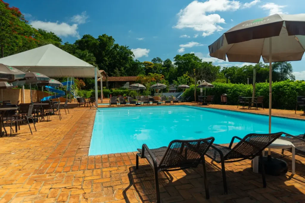 Piscina e área de lazer do Hotel Colonial Iguaçu com espreguiçadeiras e guarda-sóis