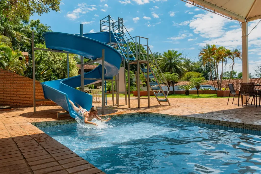 Piscina ao ar livre com espreguiçadeiras e guarda-sóis no Hotel Colonial Iguaçu